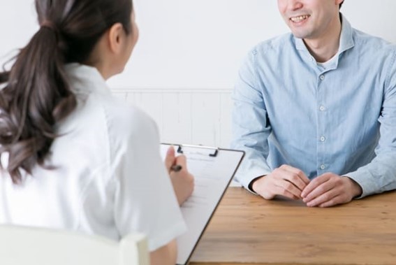 歯科衛生士と話す男性